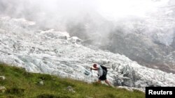 Planinar prolazi pored glečera Bionnassay, najmanjeg glečera kompleksa Mont Blanc u Francuskoj, koji se smanjuje pod uticajem globalnog zagrijavanja, prema mnogim naučnicima, 18. avgust 2021. 