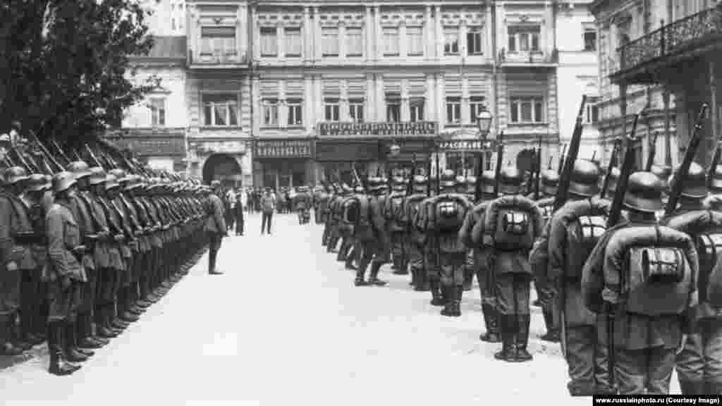 Soldați germani în Piața Maidan din Kiev, probabil în martie 1918. După Revoluția din 1917 care i-a adus pe bolșevicii lui Lenin la putere, Rusia a ieșit din Primul Război Mondial, dar negocierile oficiale pentru un acord de pace cu puterile centrale au eșuat. Germania, Austro-Ungaria și aliații lor au atacat apoi în cea mai mare parte a Ucrainei de astăzi, într-o ofensivă numită Operațiunea Pumnul, înainte ca noii conducători comuniști ai Rusiei să accepte, în sfârșit, un rușinos acord de pace.