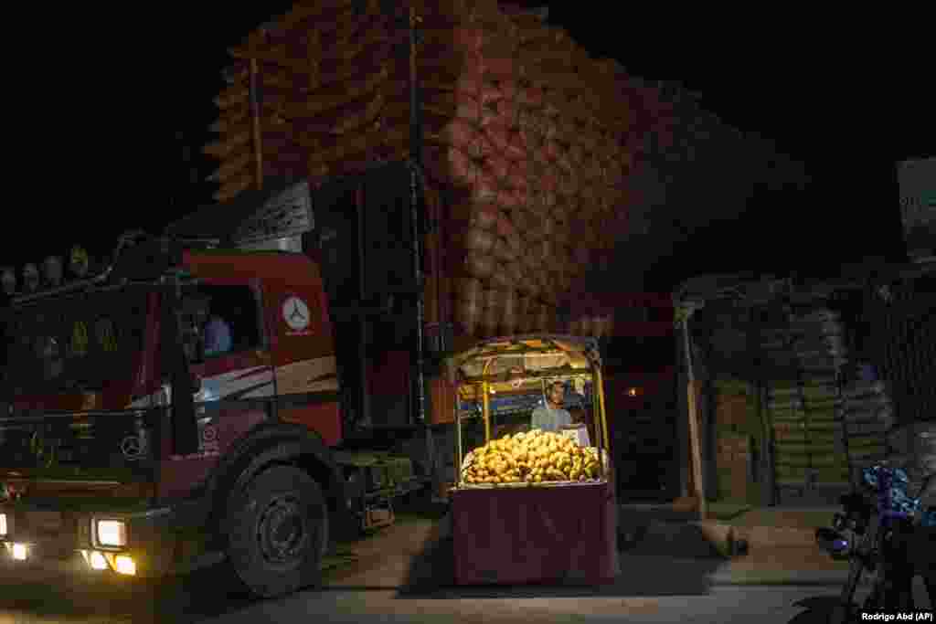 Čovjek čeka klijente dok prodaje mango na svojoj uličnoj tezgi u Kandaharu, Afganistan.