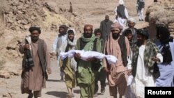 Gyereke holttestét a kezében tartó férfi Afganisztánban a földrengést követően, 2023. október 8-án