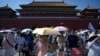 Turisti u Zabranjenom gradu u Pekingu pokušavaju kišobranima da se zaštitet od užeglog Sunca, 19. jul 2024. 