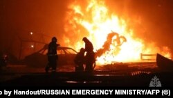 Спасители гасят пожар на бензиностанция в град Махачкала. Снимката е направена и публикувана от руското Министерство на извънредните ситуации на 14 август 2023 г.