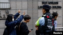 Pristalice aktivista gestikuliraju ispred zgrade suda u Hong Kongu prije izricanja presude u najvećem slučaju pod Zakonom o nacionalnoj bezbjednosti u Kini, 30 maj 2024. 