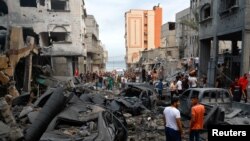 Palestinci na ulici među ruševinama nakon izraelskih napada u izbjegličkom kampu Beach, u gradu Gaza, 9. oktobra 2023. 