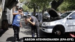 Iranski mehaničari se hlade tokom toplog i sunčanog dana u Teheranu, Iran, 5. jula 2023. 