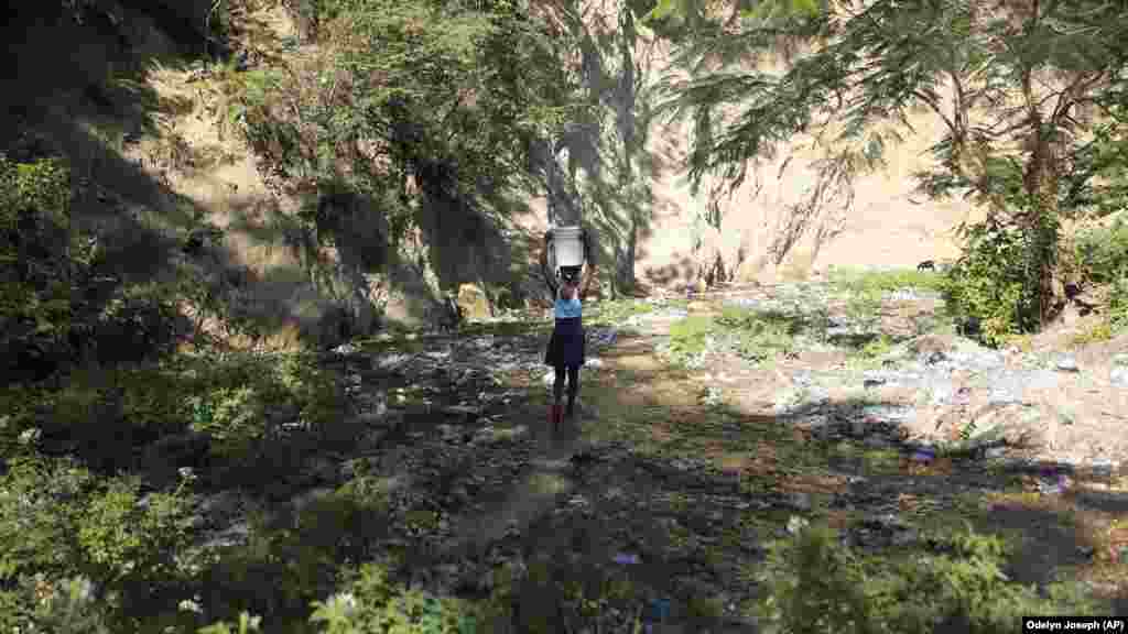 Egy fiatal lány egyensúlyoz egy vödör vízzel, amit a vízesésből gyűjtött vízzel a haiti Port-au-Prince-beli otthonuk mellett, ahol nincs folyóvizük.&nbsp; Olyan súlyos vízválsággal küzdünk, amire korábban senki nem számított&ndash; jelentette ki az ENSZ Közgyűlésének elnöke a három napos New York-i esemény zárása előtt