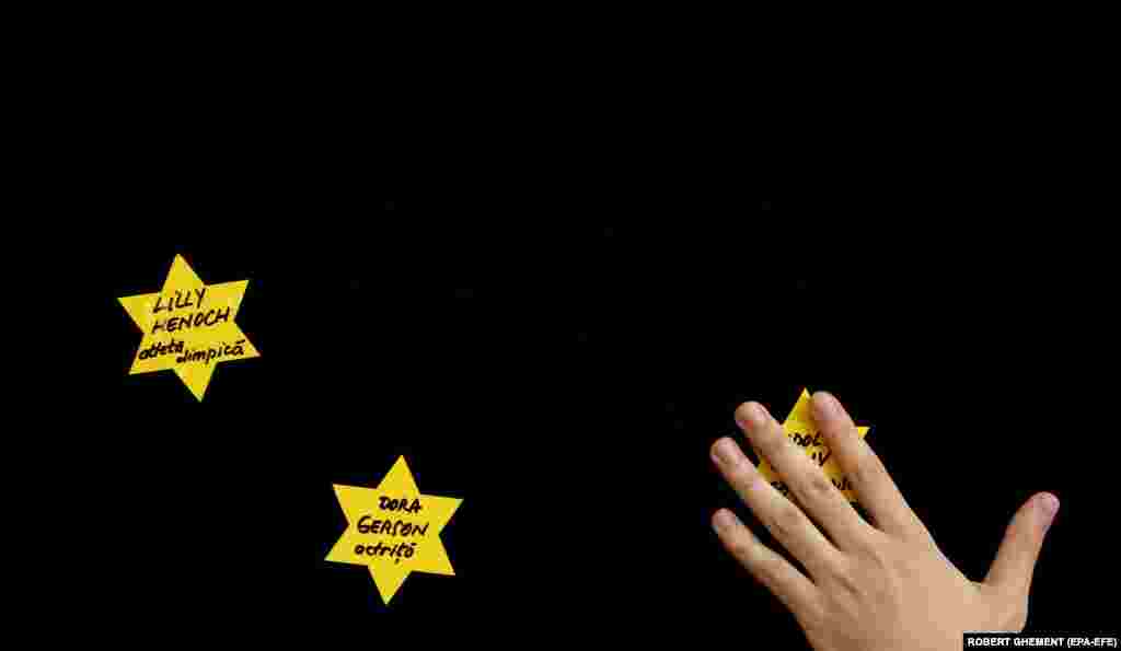 Član jevrejske zajednice lijepi žute zvijezde s imenima žrtava na posebnoj memorijalnoj službi žrtvama holokausta tokom proslave Jom HaShoah, dana sjećanja na izraelski holokaust, u Centru Jevrejske zajednice u Bukureštu 18. aprila.