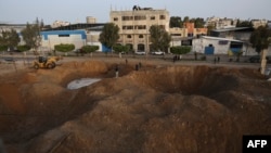 Palestinezët duke ecur në një zone të shkatërruar pasi Izraeli nisi sulmet ajrore në enklavën palestineze mëngjesin e 7 prillit 2023.