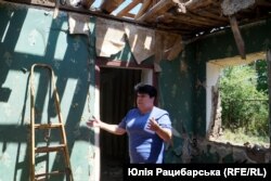 Тетяна біля знищеного обстрілами будинку