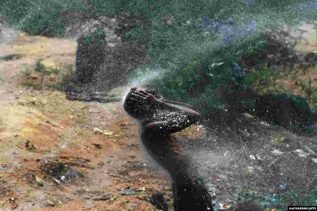 Muškarac se hladi vodom tokom vrućeg dana u Karačiju u Pakistanu.