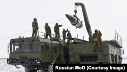 Ресей әскерилері ядролық ракетаны көлікке тиеп жатыр. 