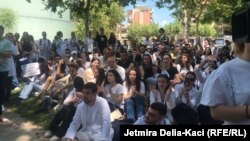 Një grup studentësh të mjekësisë duke qëndruar ulur, gjatë një proteste para Kuvendit të Shqipërisë.