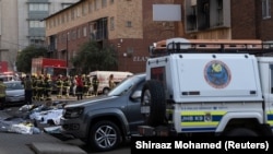 Tijela žrtava poredana su na cesti pored zgrade koje je gorila u centru Johannesburga, 31. avgust