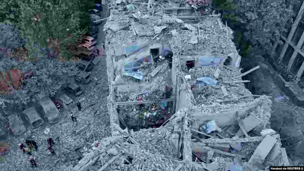 Mentők nézik át egy lakóépület törmelékeit túlélők után kutatva. Andrij Szadovij polgármester a város polgári infrastruktúrája ellen elkövetett egyik legnagyobb támadásnak nevezte a csütörtöki akciót, amelyben összesen harmincöt lakóház, egy irodakomplexum, egy diákkollégium, egy iskola és több tucat autó rongálódott meg