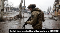 Воїн ЗСУ прочісує вулицю Бахмута