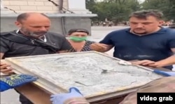 Віряни очищають Касперовську ікону Божої Матері, яку дістали з-під уламків після ракетного удару по Спасо-Преображенському собору в Одесі. 23 липня 2023 року