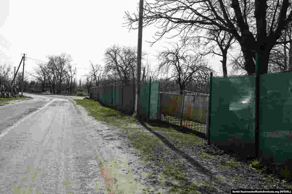 Кіт сидить на плечі дитини, яку разом з мамою евакуйовують із села Рудницьке, Київщина, березень 2022 року / Праворуч: та ж вулиця у березні 2024 року