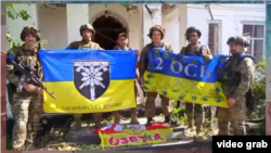 Ukrán katonák ukrán zászlókkal a Zaporizzsjai területen, Pjatihatki falu felszabadítása után, 2023. június 19-én