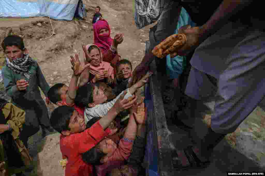 Volonteri dijele hljeb ljudima pogođenim poplavama u blizini sela Shirjalal.