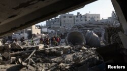 Câțiva palestinieni inspectează urmările unui atac israelian asupra moscheii al-Farouk și a unor case, Rafah, sudul Fâșiei Gaza, 22 februarie 2024.