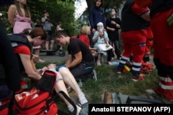 Медики надають допомогу місцевим жителям після російського ракетного удару по Києву, 8 липня 2024 року