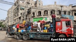 Odamenekült palesztinok menekülnek tovább a rafahi Tal al-Szultán negyedből az izraeli légicsapások után 2024. május 28-án