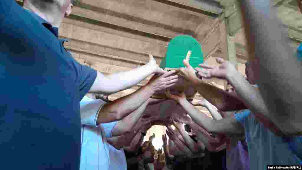 Građani prenose tabute sa posmrtnim ostacima žrtava srebreničkog genocida u Memorijalni centar Potočari. &nbsp;