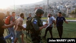 Ізраїльські сили безпеки та медики перевозять поранених із місця, де, як повідомляється, був завданий удар по стадіону на Голанських висотах, 27 липня 2024 року