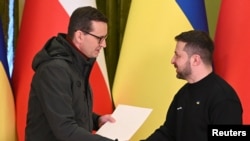 Prim-ministrul polonez Mateusz Morawiecki (stânga) și președintele ucrainean Volodimir Zelenski în timpul unei conferințe de presă comune la Kiev, la 24 februarie.
