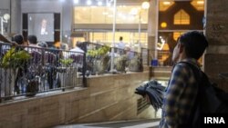 دستفروشی در تهران در حال تماشای مناظره انتخابات چهاردهمین دوره ریاست‌جمهوری