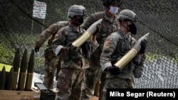 Курсанти Військової академії США очікують зарядку бойових 105-мм снарядів у артилерійську зброю M119 105-мм гаубицю в рамках літньої підготовки кадетів у Вест-Пойнті. Нью-Йорк, 2020 рік.