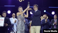 Фестивалдын жеңүүчүсү Айна Калмаганбетовага Эдил Байсалов сыйлык тапшырып жатат.