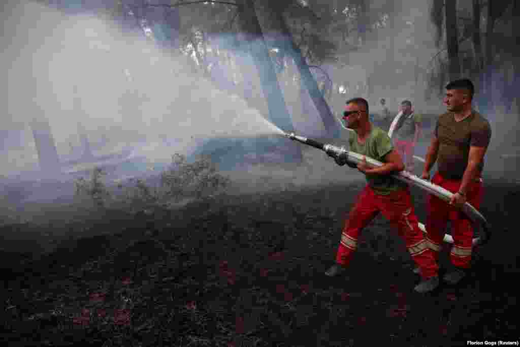 Ushtarakët duke hedhur ujë mbi flakët afër Cakranit.