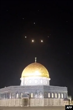 O imagine capturată dintr-un videoclip realizat la începutul zilei de 14 aprilie 2024 arată trasee de rachete pe cer de deasupra complexului Moscheea Al-Aqsa din Ierusalim.