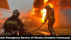 Пожежники ліквідовують пожежу, що виникла внаслідок падіння уламків ракети під час російської атаки. Київська область, 12 червня 2024 року