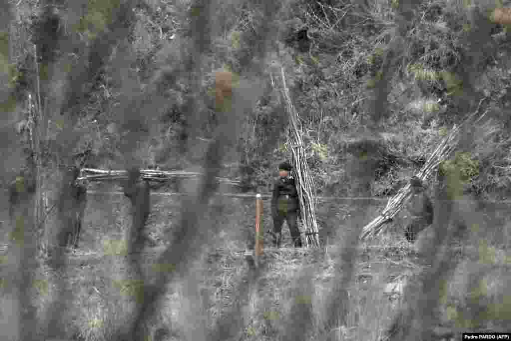 Sjevernokorejski vojnici gledaju preko zaleđene rijeke prema Kini, povremeno se spuštajući sa osmatračnica kako bi šetali graničnim stazama iza bodljikave žice. &nbsp;