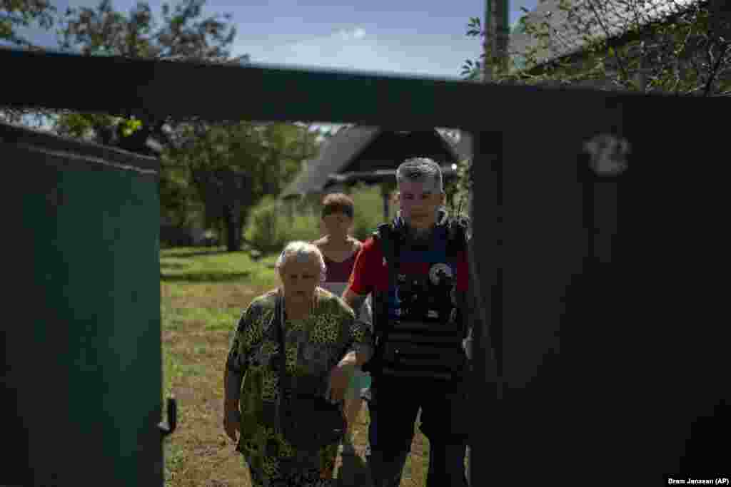 Волонтер Євген Кириченко допомагає Ніні Ситниковій дістатися до евакуаційного автомобіля. Українська влада оголосила евакуацію на тлі концентрації російських військ на цій ділянці з метою нового наступу.