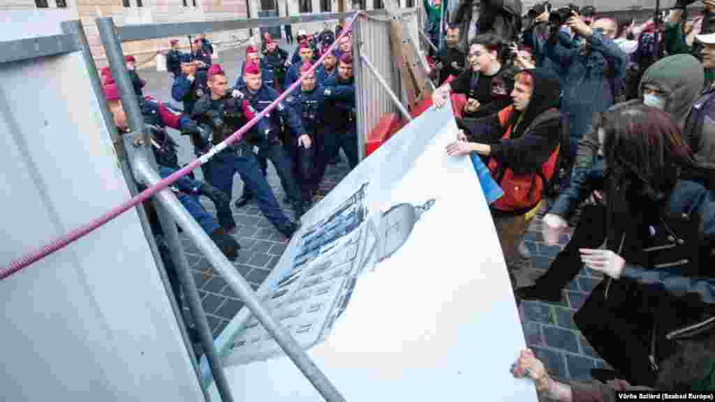 A Központi Nyomozó Főügyészség sajtóközleményében azt írja, hogy a Budapesti Regionális Nyomozó Ügyészség csoportosan elkövetett, hivatalos személy elleni erőszak bűntette miatt nyomoz a&nbsp;2023. május 3-án este a Karmelita kolostor előtti tüntetésen történő, rendőrök elleni támadással kapcsolatban. Az ügyben egy személyt vettek őrizetbe; az eljárás érdekeire hivatkozva más tájékoztatást nem adnak
