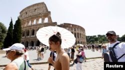 Turiștii afectați de caniculă merg pe lângă Colosseum în timpul valului de căldură care afectează Italia, în timp ce se așteaptă ca temperaturile să crească și mai mult în următoarele zile, Roma, Italia, 17 iulie 2023.
