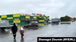 Женщина в никабе идет с девочкой школьного возраста к рынку в Актобе. 6 октября 2023 года