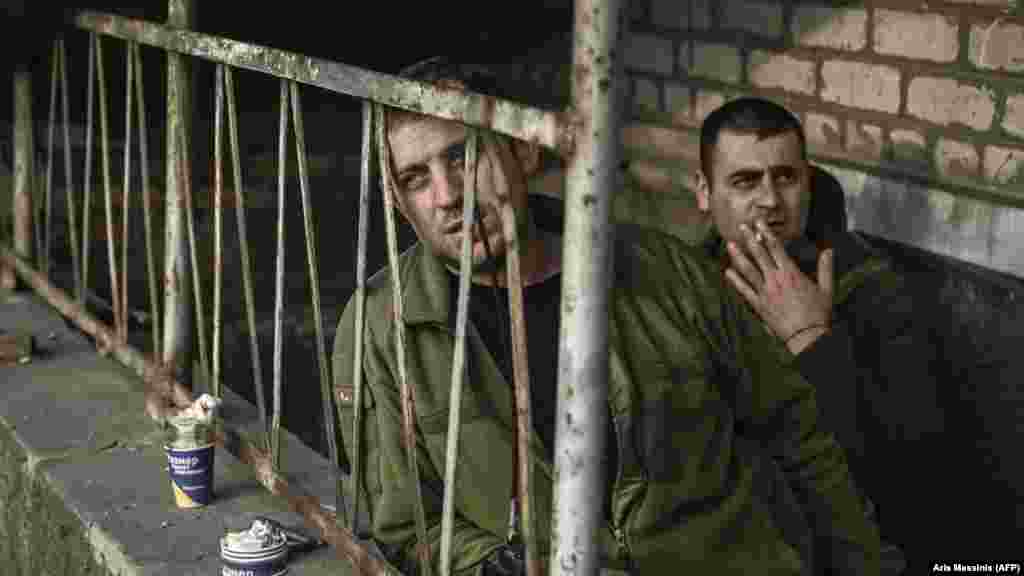 Ukrán katonák cigarettáznak a bunkerük kijáratánál