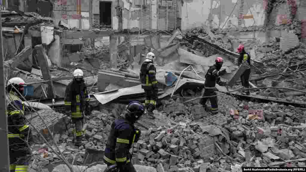 Tűzoltók holttestek után kutatnak egy orosz rakéta által megsemmisített épület romjai között 2024. március 25-én Kijevben