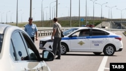 Крым көпүрөсүндө турган полиция кызматкерлери. 17-июль, 2023-жыл. Орусия аннексиялап алган Украинанын Крым аймагы.
Сергей Мальгавко/ТАСС