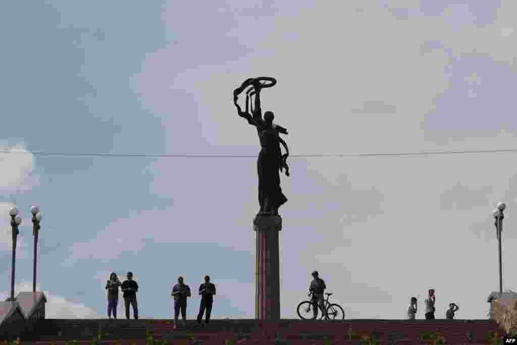 Stanovnici posmatraju djelimično poplavljeno područje i kako voda raste u Hersonu.