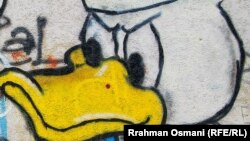 Fotografia jo e plotë e muralit (Radio Evropa e Lirë ka zgjedhur të mos e publikojë fotografinë e plotë të muralit, për shkak të mesazhit të dhunshëm që përmban)
