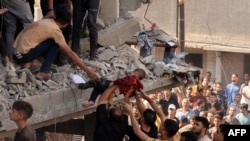 Spasioci izvlače dijete iz ruševina zgrade pogođene u izraelskim vazdušnim napadima u Khan Yunisu u južnom pojasu Gaze, 24. oktobra 2023. godine.