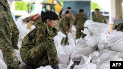 Hrvatski vojnici pomažu u postavljanju vreća s pijeskom za odbranu od poplava, Karlovac, 17. maj