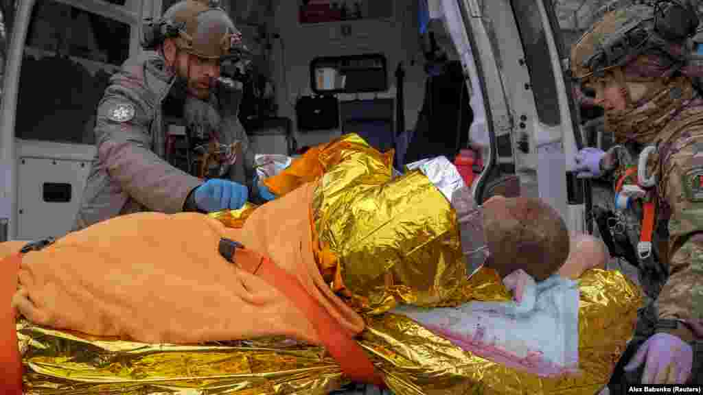 Ljekari nose ranjenog ukrajinskog vojnika u vozilo hitne pomoći prije polaska u bolnicu ispred prve medicinske stabilizacijske tačke usred ruskog napada na Ukrajinu.