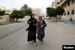 Palestinke hodaju ulicama Gaze nakon izraelskih napada, 9. oktobra