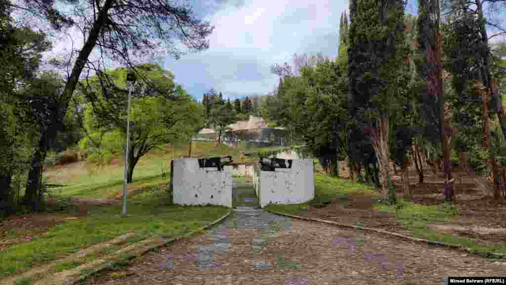 Ulaz u kompleks Partizanskog spomen-groblja u Mostaru. Taj spomenik je u više navrata bio meta napada, skrnavljenja i rušenja. Lokalne vlasti su 7. januara 2022. godine, nakon što je ulaz ponovo oštećen uvredljivim grafitima, naredile farbanje zida bijelom bojom.